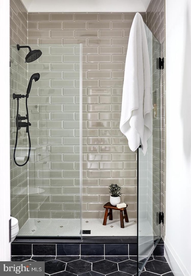 bathroom featuring an enclosed shower and toilet