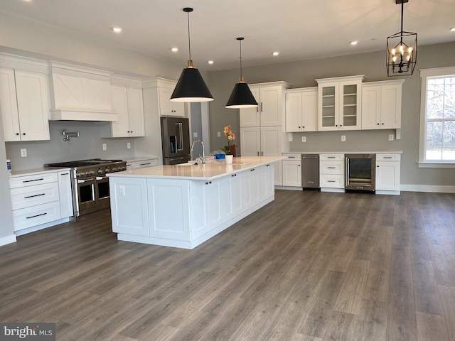 kitchen featuring pendant lighting, white cabinets, dark hardwood / wood-style floors, and premium appliances