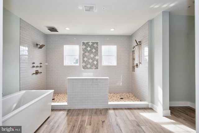 bathroom with hardwood / wood-style floors and independent shower and bath