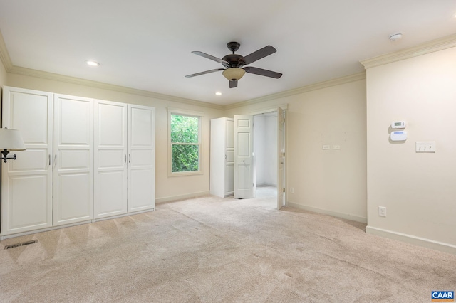 unfurnished bedroom with crown molding, light carpet, and ceiling fan