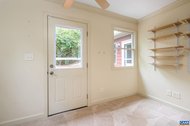 doorway featuring a healthy amount of sunlight, carpet flooring, ornamental molding, and ceiling fan