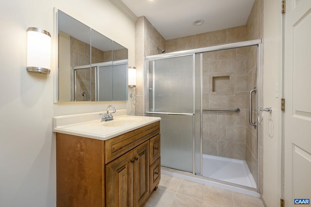 bathroom with tile patterned floors, a shower with door, and vanity