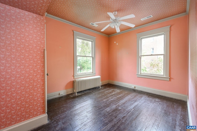 empty room with crown molding, ceiling fan, radiator heating unit, and dark hardwood / wood-style flooring