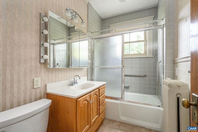 full bathroom featuring shower / bath combination with glass door, vanity, toilet, and tile patterned floors