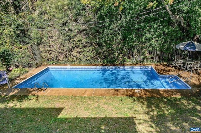 pool with a lawn and a patio area