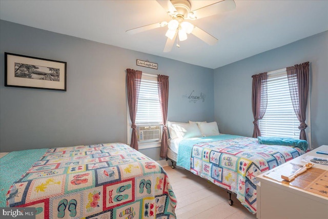 bedroom featuring multiple windows, cooling unit, and ceiling fan