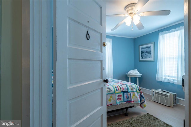 bedroom with a wall mounted AC, ceiling fan, and ornamental molding