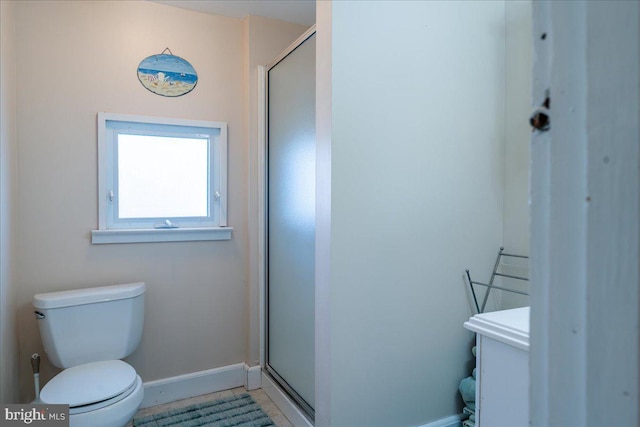 bathroom featuring tile patterned floors, toilet, and a shower with shower door