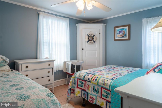 bedroom featuring an AC wall unit, ceiling fan, crown molding, and light wood-type flooring