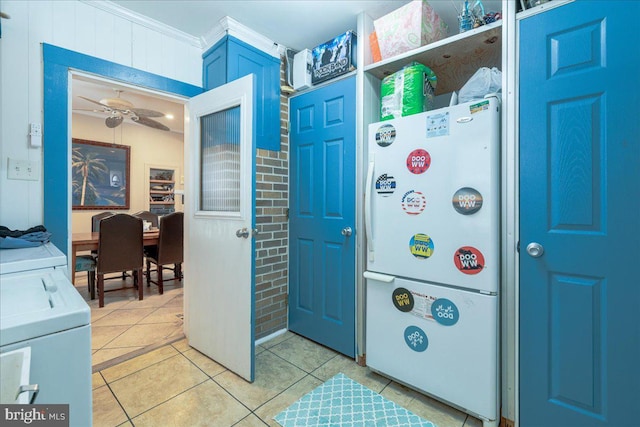 interior space with ceiling fan, light tile patterned flooring, ornamental molding, and independent washer and dryer