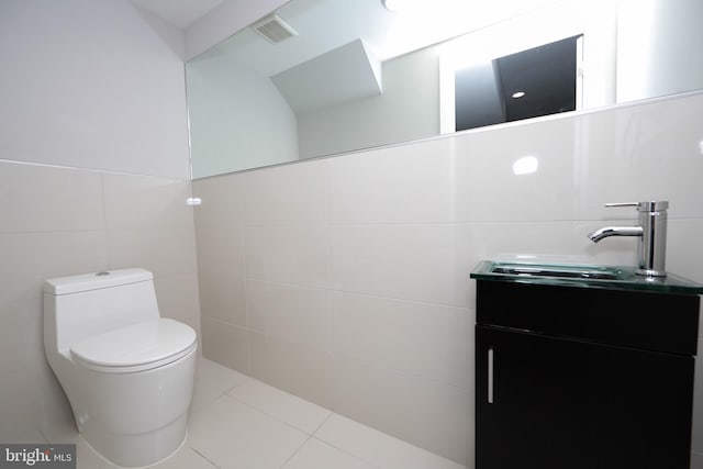 bathroom with tile walls, tile floors, toilet, and vanity