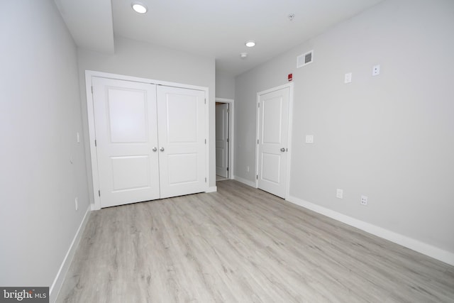 unfurnished bedroom with a closet and light hardwood / wood-style floors