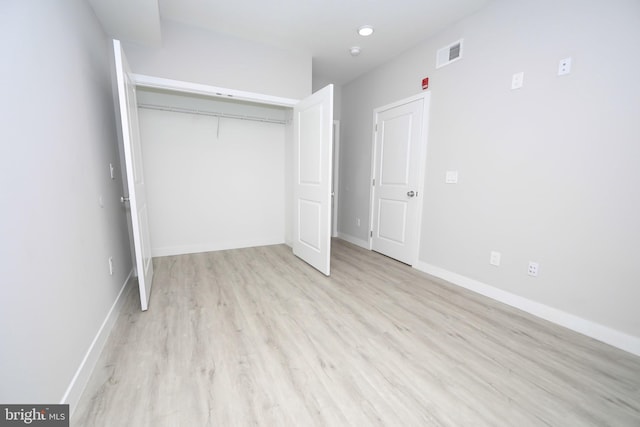 unfurnished bedroom with a closet and light hardwood / wood-style flooring