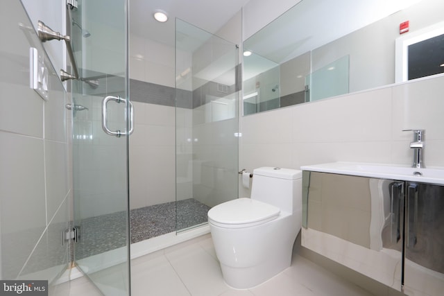 bathroom featuring toilet, vanity, tile walls, tile flooring, and an enclosed shower