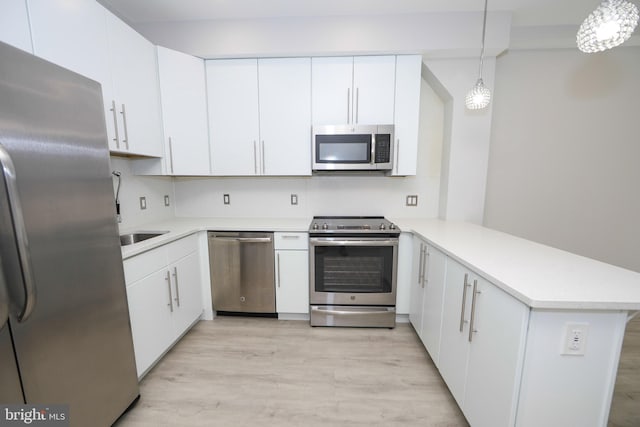 kitchen with appliances with stainless steel finishes, light hardwood / wood-style flooring, and white cabinets