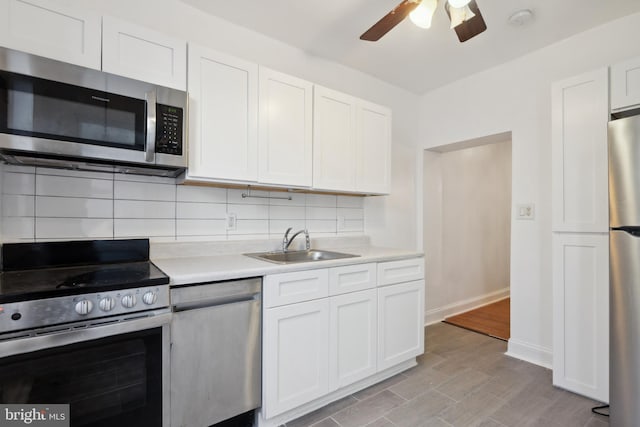 kitchen featuring appliances with stainless steel finishes, backsplash, light hardwood / wood-style flooring, and white cabinetry