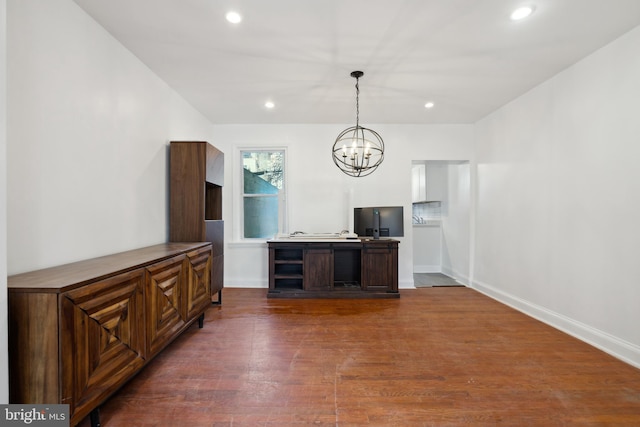 unfurnished living room with an inviting chandelier and dark hardwood / wood-style floors