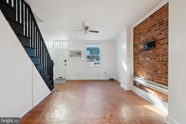 entrance foyer featuring brick wall, ceiling fan, and light hardwood / wood-style flooring