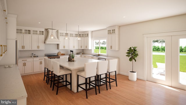 kitchen with custom range hood, a kitchen island, white cabinetry, and light hardwood / wood-style flooring