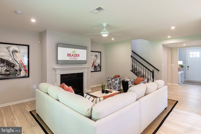 living room with light hardwood / wood-style floors and ceiling fan