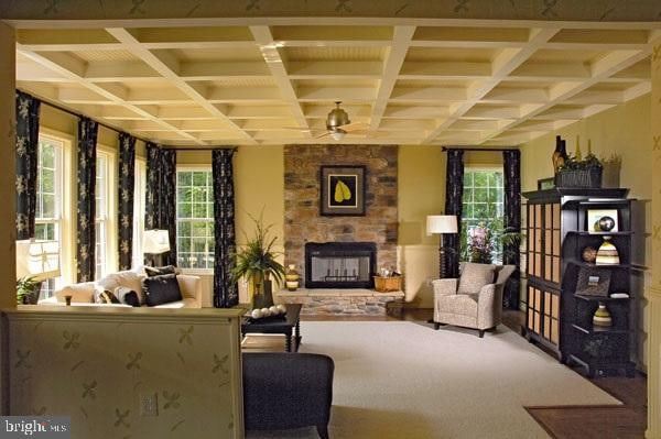 living area with coffered ceiling, plenty of natural light, carpet, and a fireplace