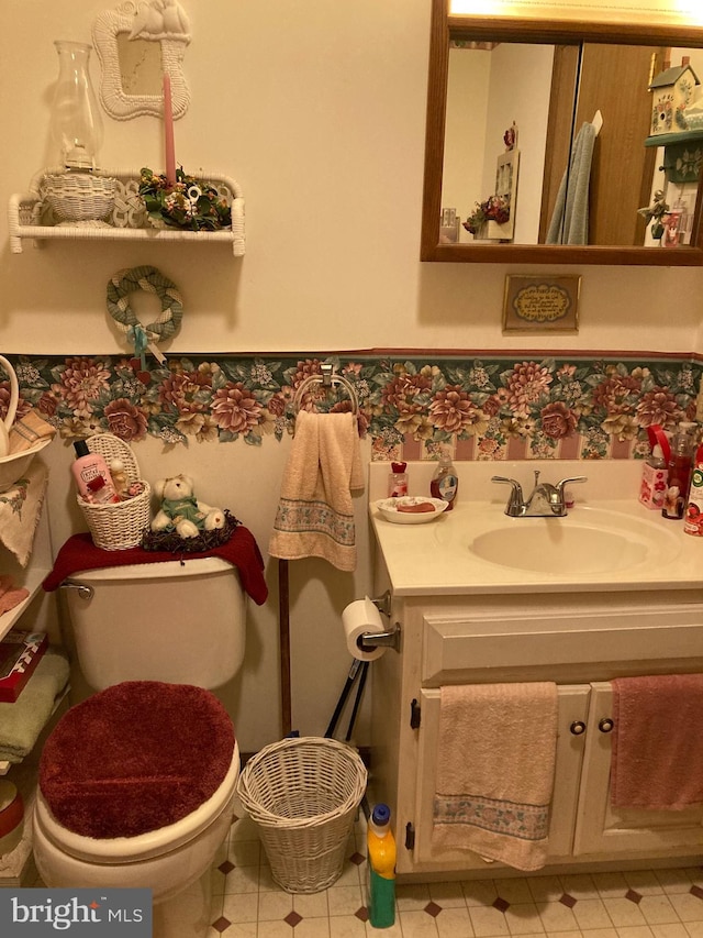 bathroom with toilet, tile floors, and vanity