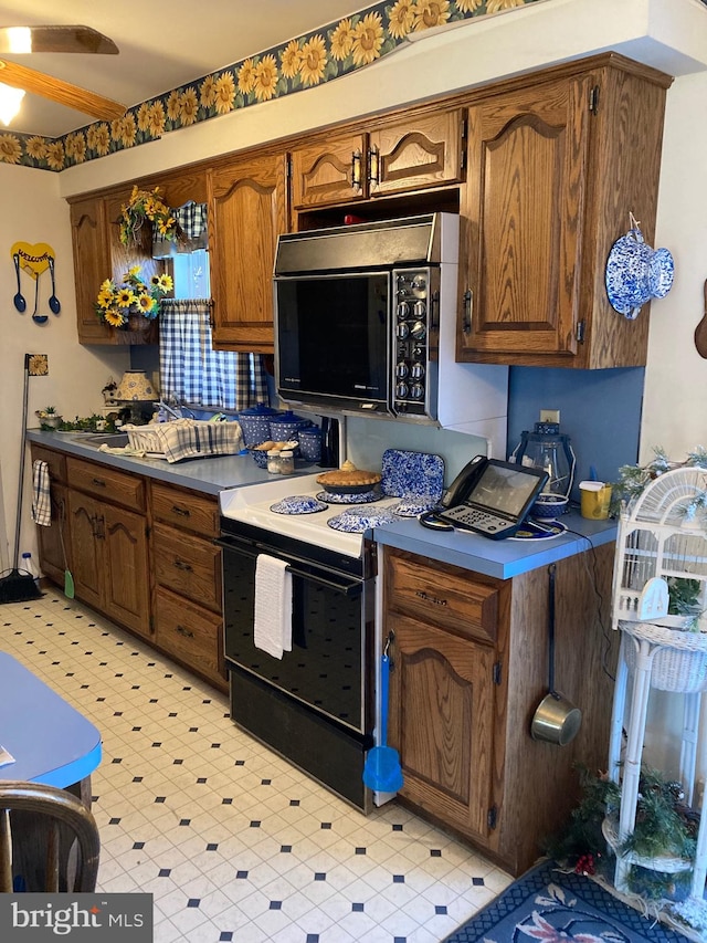 kitchen featuring range with electric stovetop, ceiling fan, and light tile floors