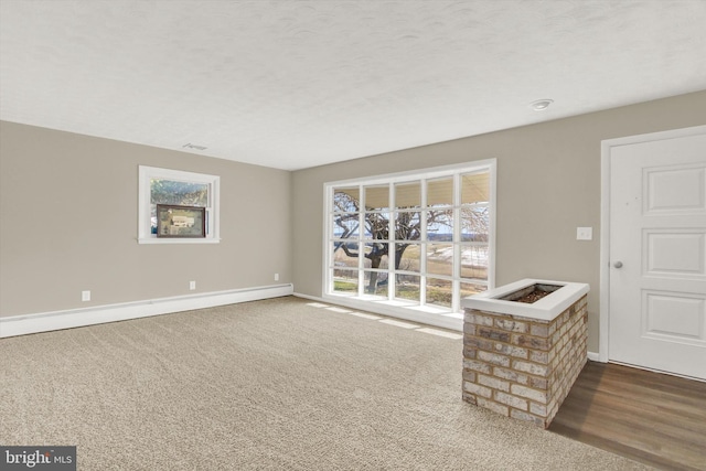 carpeted spare room with a baseboard radiator