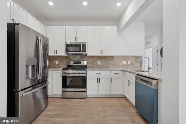 16423 River View Dr, Bristol, PA 19007 - kitchen featuring stainless steel appliances, a sink, light stone countertops, white cabinets, and recessed lighting