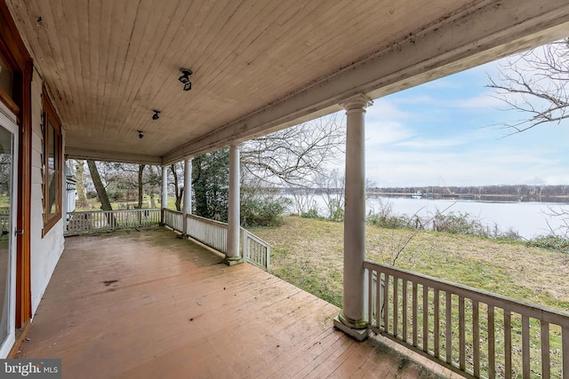 wooden terrace featuring a water view