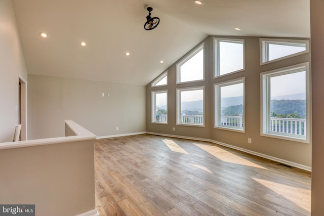 interior space featuring a mountain view, light hardwood / wood-style flooring, and high vaulted ceiling