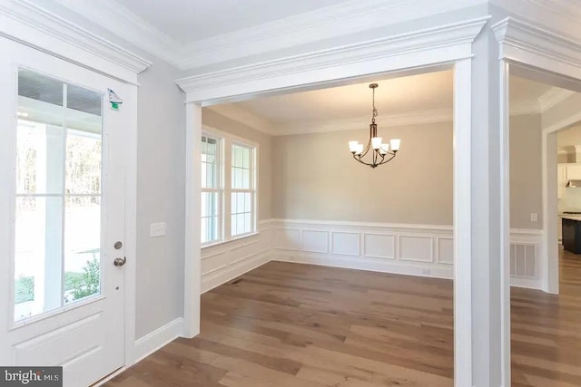 foyer featuring an inviting chandelier, dark hardwood / wood-style floors, and ornamental molding