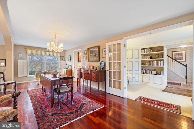 dining area featuring dark hardwood / wood-style floors, an inviting chandelier, and built in features