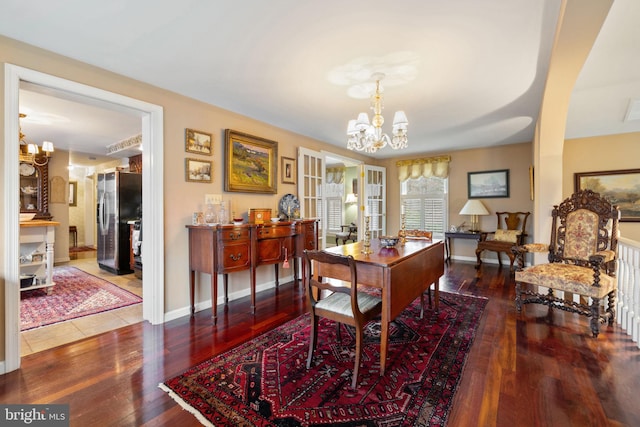 dining area with dark tile floors and a chandelier