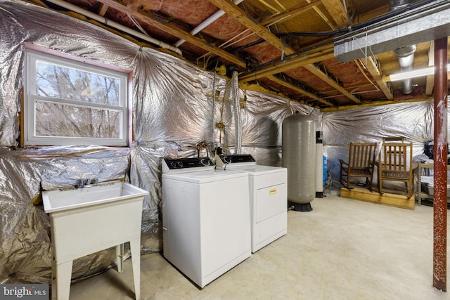 laundry area featuring washer and dryer, gas water heater, and sink