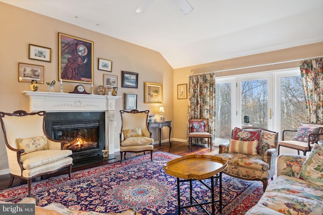 living room with lofted ceiling, ceiling fan, and dark wood-type flooring