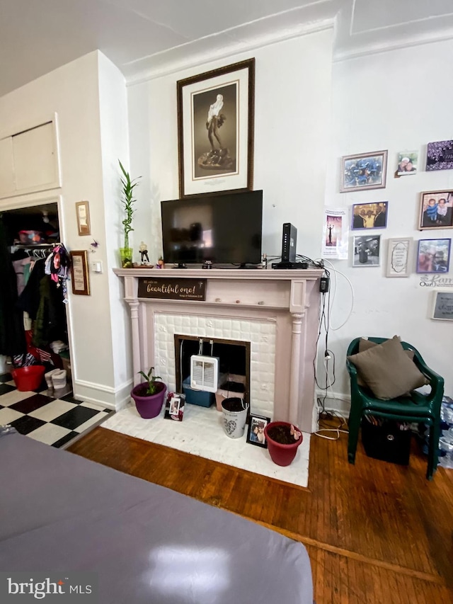 living room with a brick fireplace and dark hardwood / wood-style floors