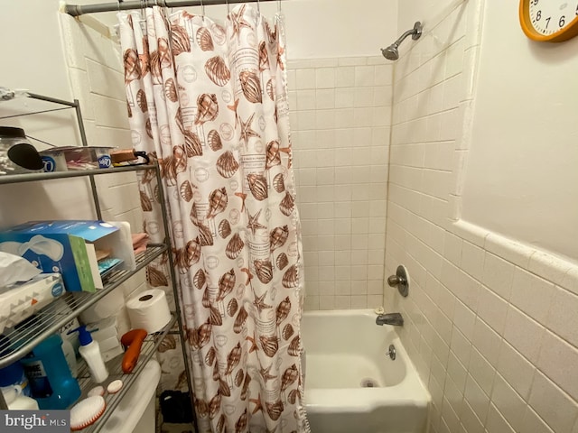 bathroom with tile walls and shower / bath combo