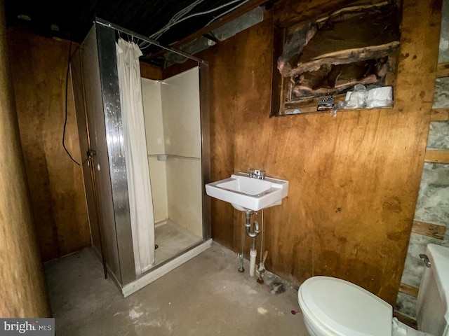 bathroom featuring concrete floors, sink, toilet, and a shower with curtain