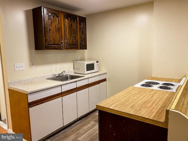 kitchen featuring sink, dark brown cabinetry, and hardwood / wood-style flooring