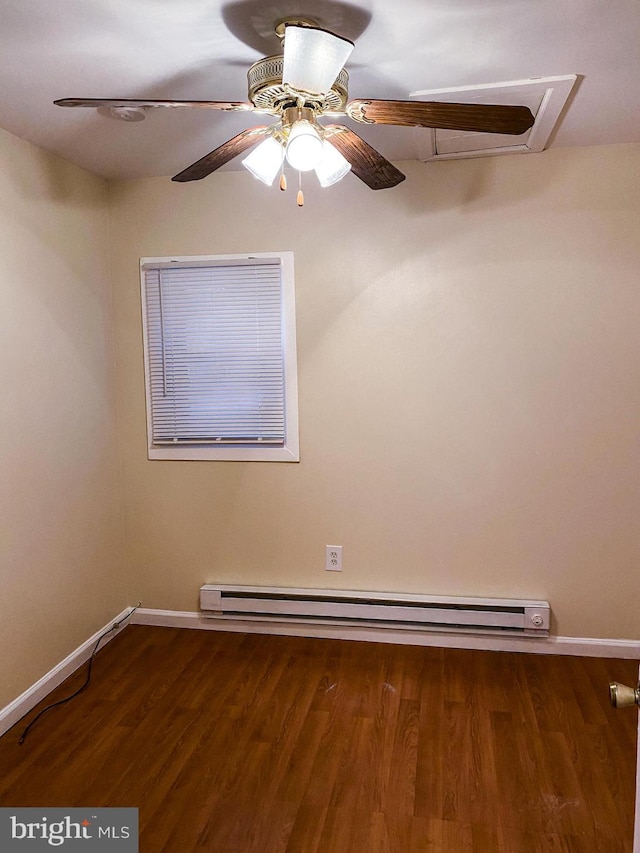 spare room featuring ceiling fan, baseboard heating, and dark hardwood / wood-style flooring