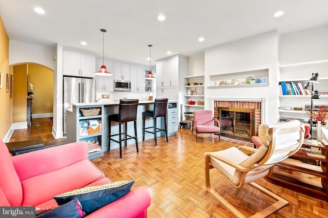 living room with a fireplace and light parquet floors