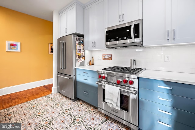 kitchen featuring white cabinetry, tasteful backsplash, premium appliances, blue cabinets, and light parquet flooring