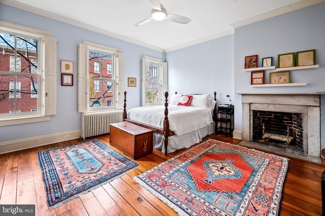 bedroom with crown molding, ceiling fan, wood-type flooring, and radiator