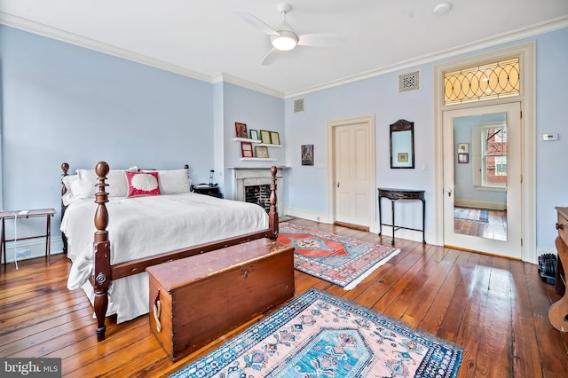 bedroom featuring hardwood / wood-style floors, ornamental molding, and ceiling fan