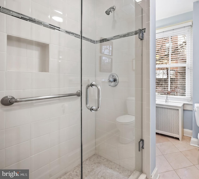 bathroom featuring tile patterned flooring, radiator heating unit, an enclosed shower, and toilet