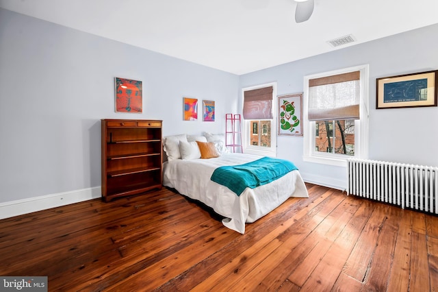 bedroom featuring dark wood-type flooring, ceiling fan, and radiator heating unit