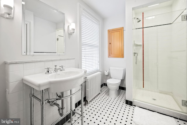 bathroom featuring radiator, an enclosed shower, and toilet