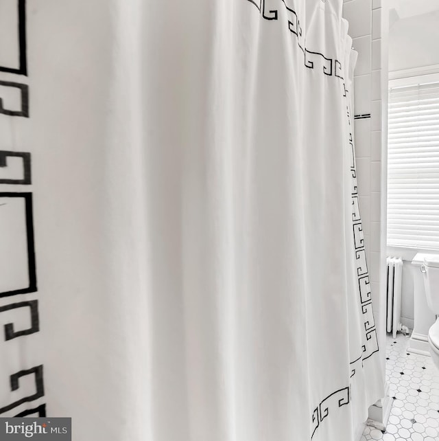 bathroom with radiator, tile patterned floors, and toilet