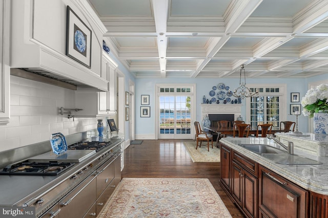 kitchen with coffered ceiling, white cabinetry, backsplash, a notable chandelier, and dark hardwood / wood-style flooring